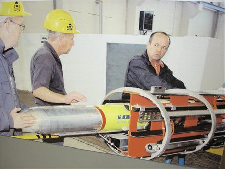 Des ingénieurs de HDW glissent un missile d'essai dans le conteneur de lancement
