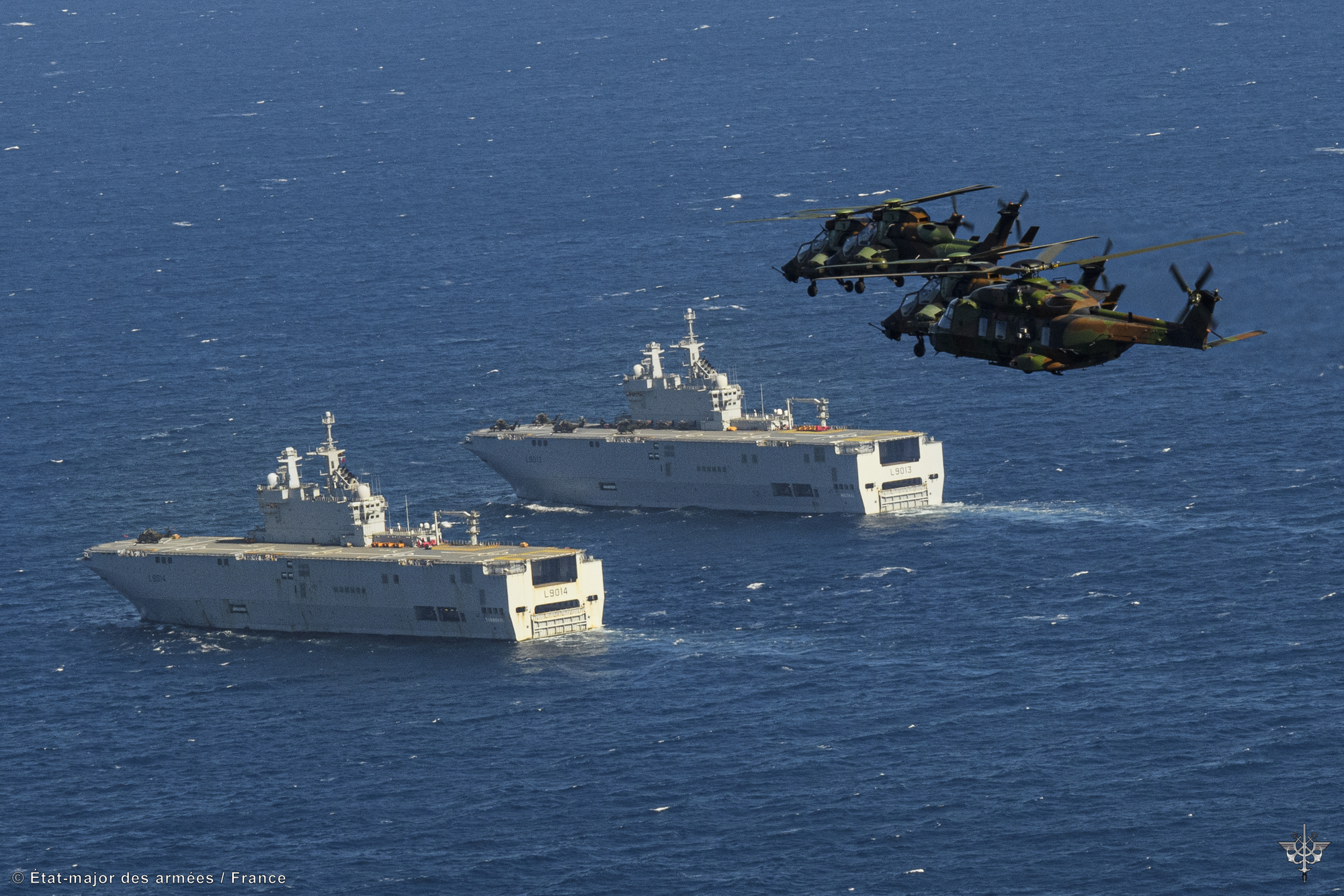Des hélicoptères de l'armée de terre survolent les porte-hélicoptères amphibies