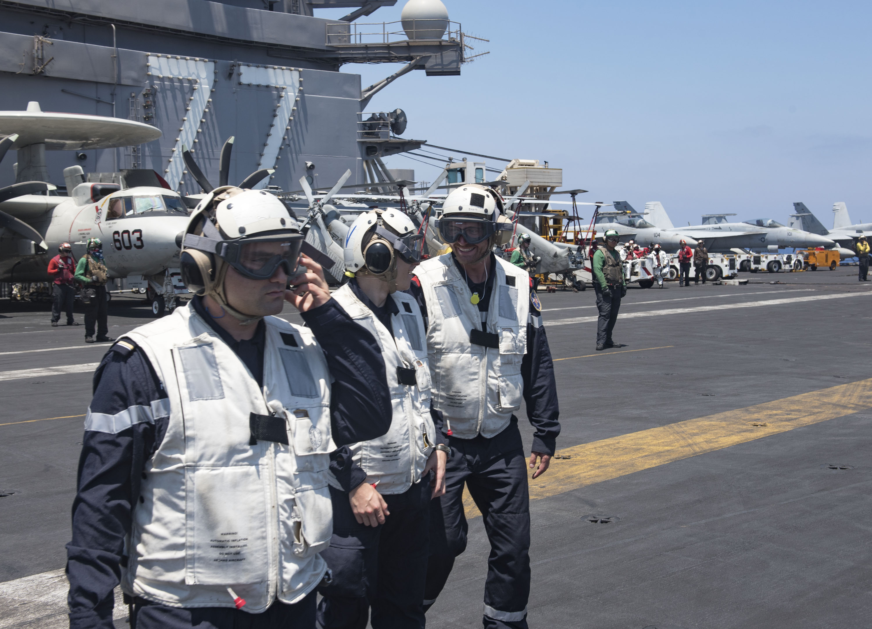 Des marins de la frégate Chevalier Paul assistent aux opérations aériennes sur le pont de l'USS George H.W. Bush