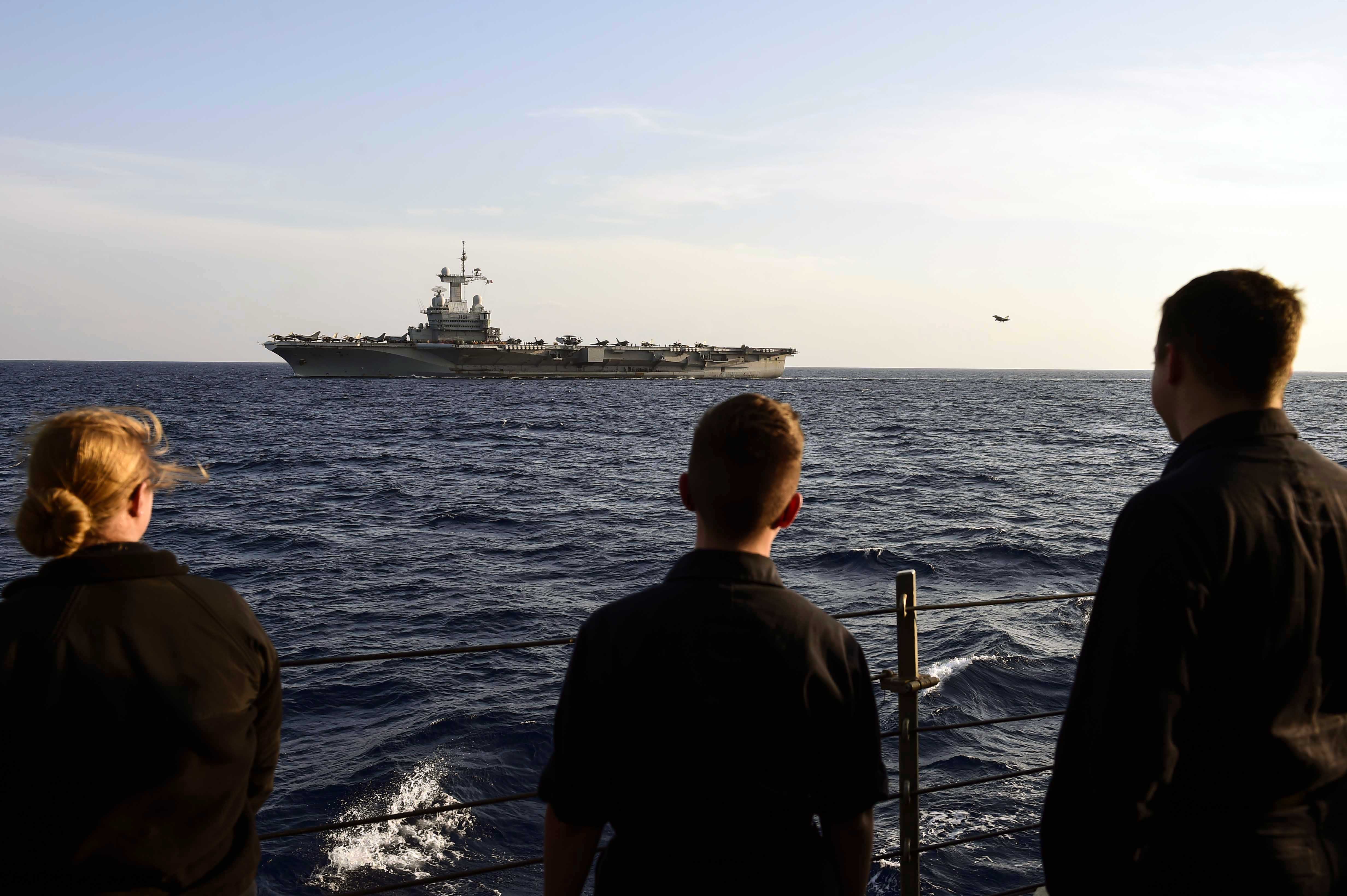 Des marins de l'USS Ross assistent aux opérations aériennes sur le porte-avions Charles de Gaulle