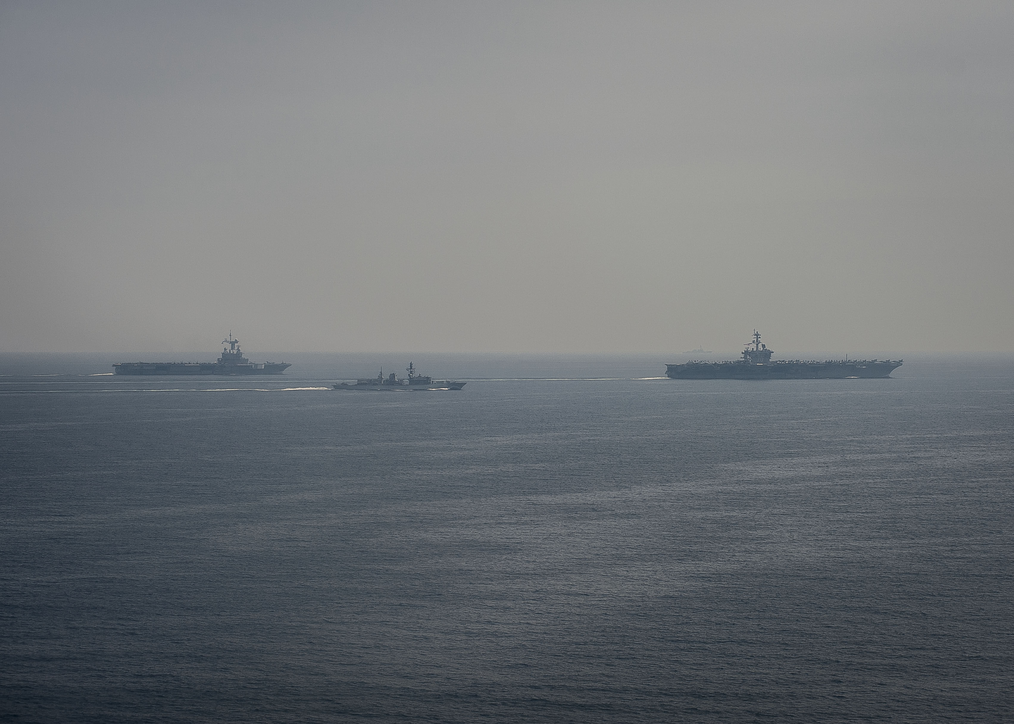 Le porte-avions Charles de Gaulle (à gauche), la frégate britannique HMS Kent (au centre), et le porte-avions américain USS Carl Vinson (à droite) naviguent en formation dans le golfe Persique