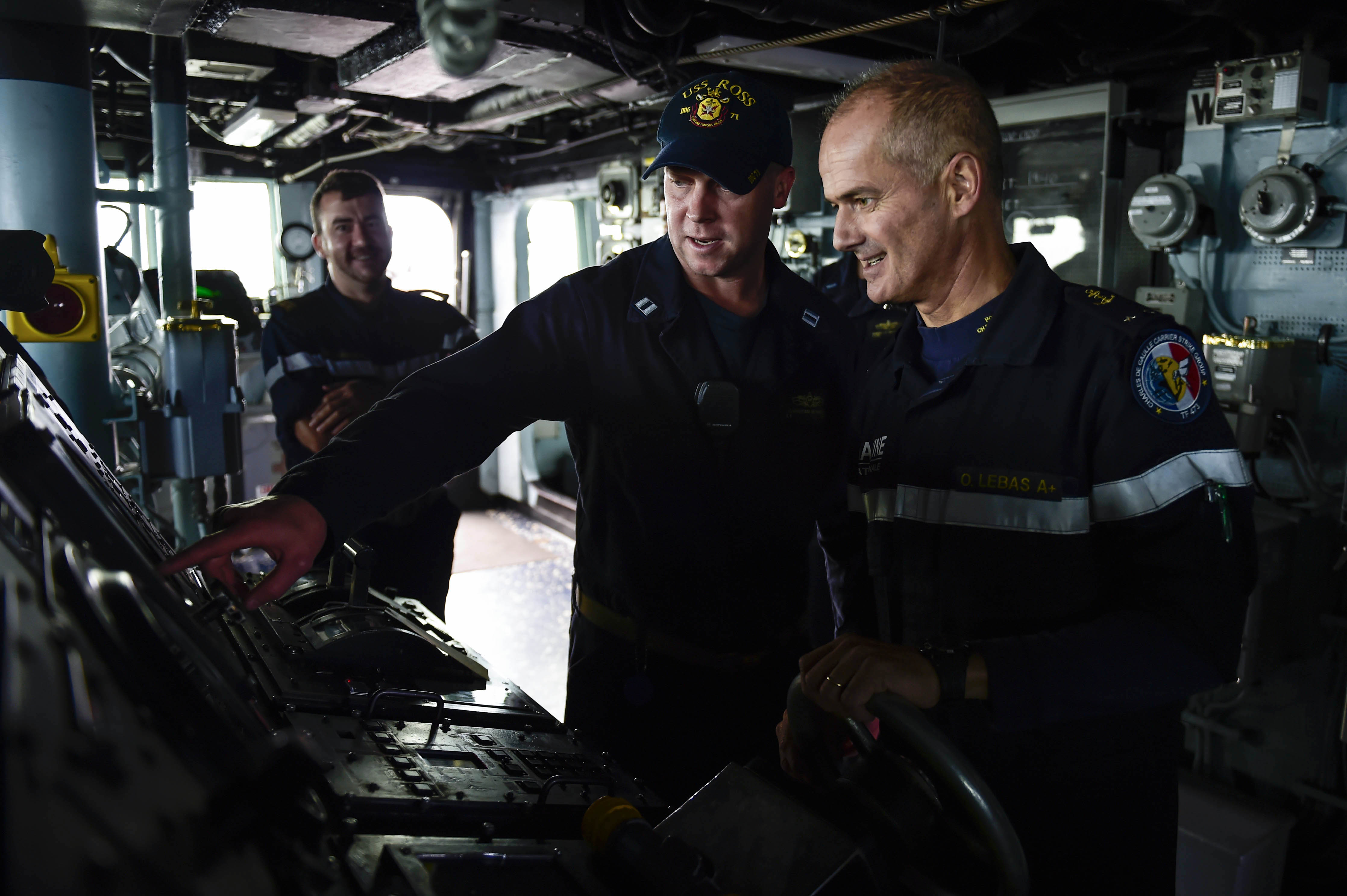 Le Cmdr. Russell Caldwell, commandant de l’USS Ross, fait visiter son destroyer au contre-amiral Lebas