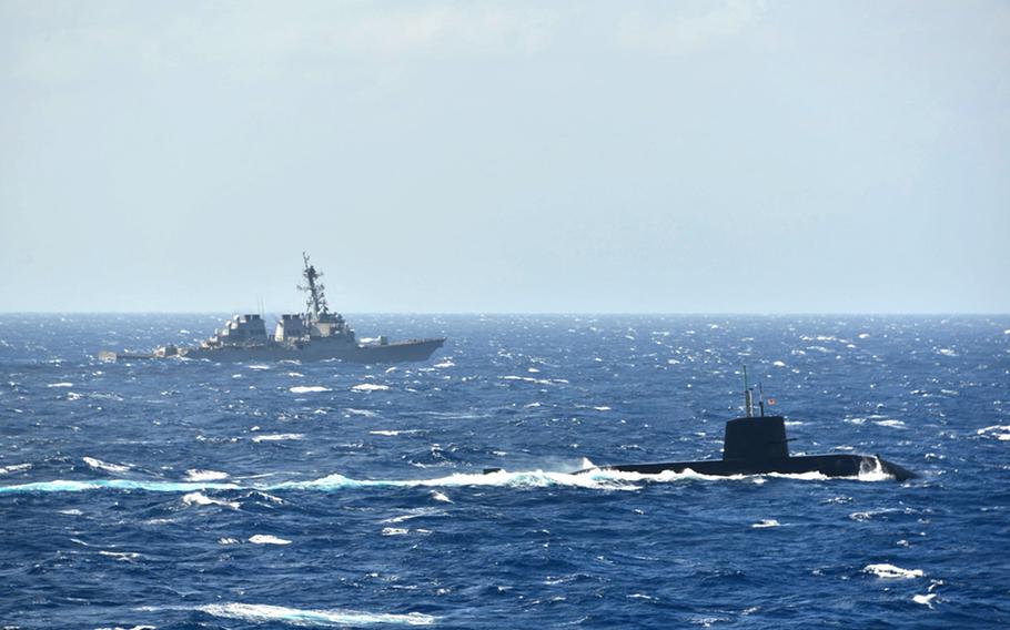 Le destroyer USS Milius navigue aux côtés d'un sous-marin japonais