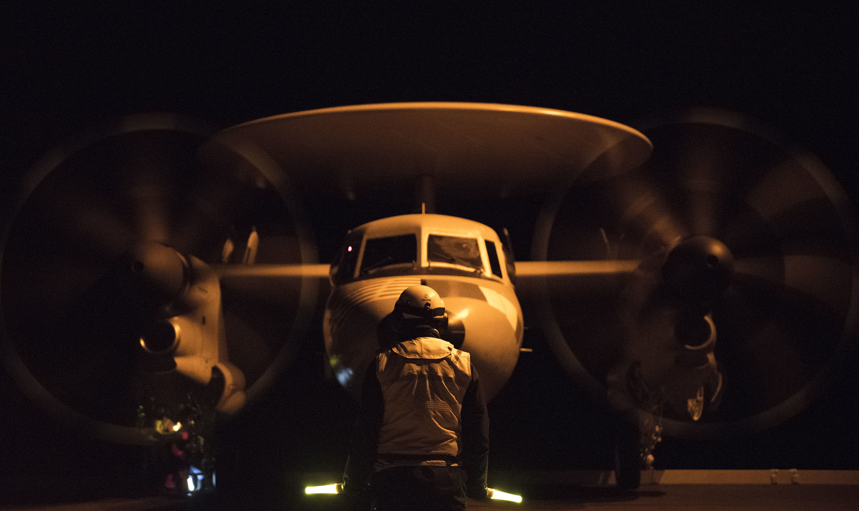 Un avion de guet aérien E2C - Hawkeye se prépare à décoller de nuit du porte-avions USS George H.W. Bush
