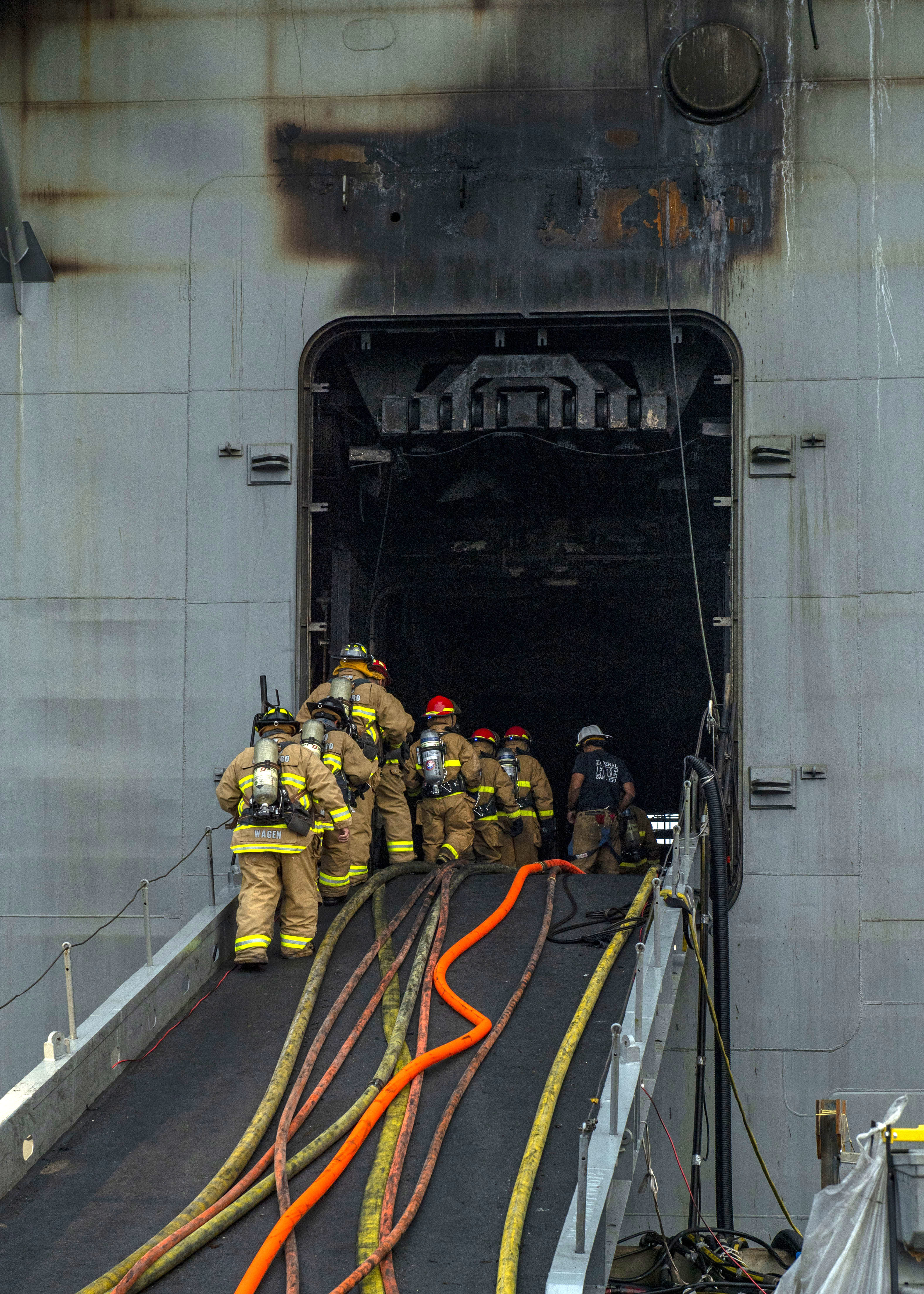 Des pompiers montent à bord de l'USS Bonhomme Richard