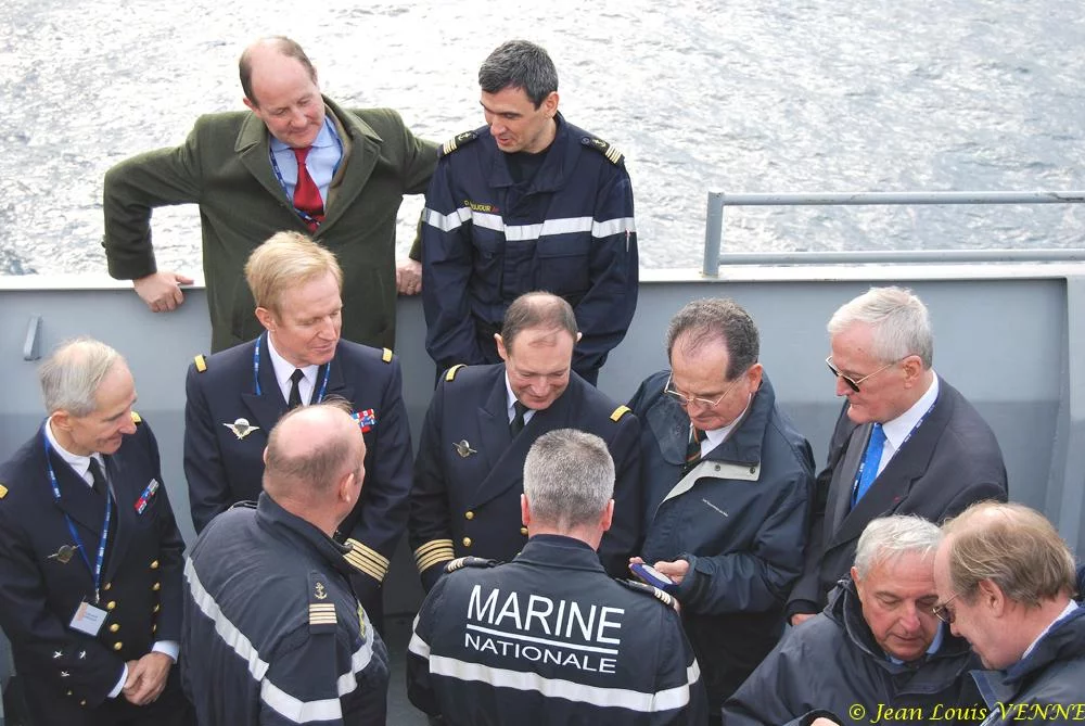 Le commandant actuel remet à un de ses prédécesseurs une médaille et une casquette