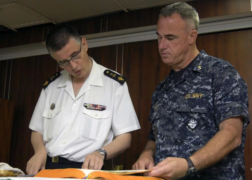 Pascal Frey, à gauche, lit les Ecritures avec le chapelain américain Tom Ianucci avant de célébrer une messe commune catholique à bord du porte-avions américain USS Harry S. Truman