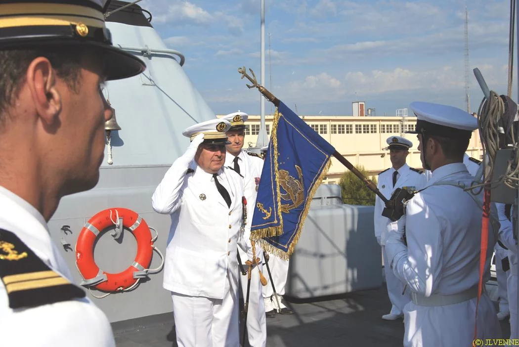Le capitaine de vaisseau Jubelin salue le fanion