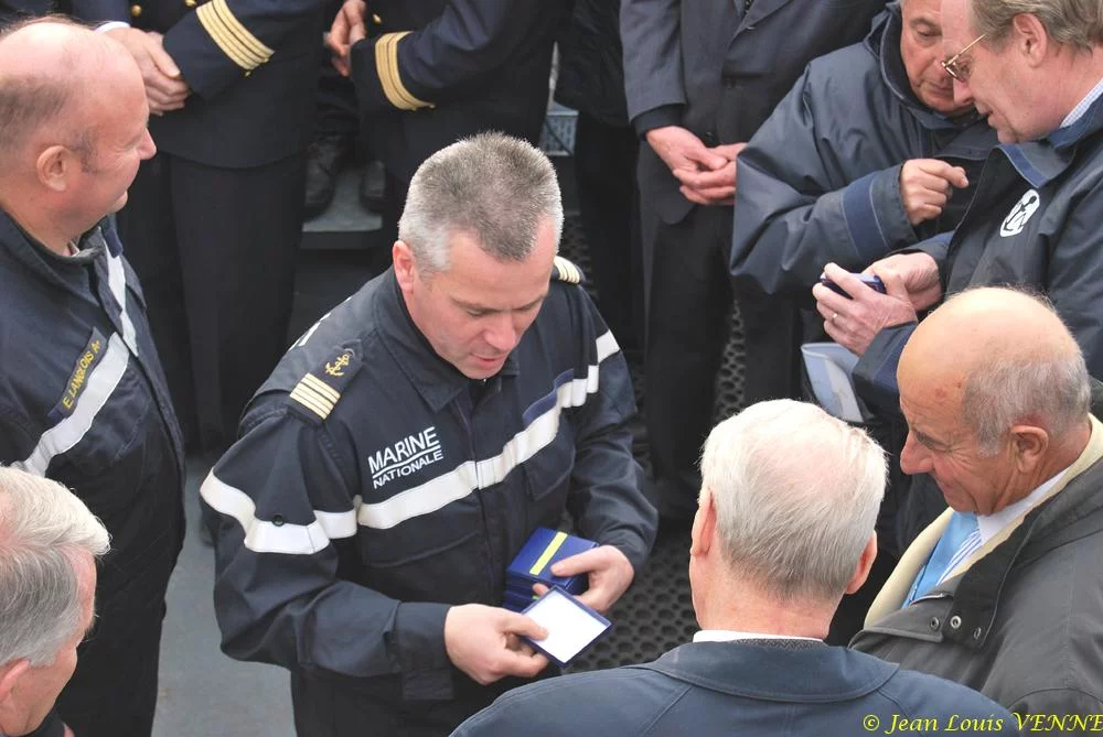 Le commandant actuel remet à un de ses prédécesseurs une médaille et une casquette