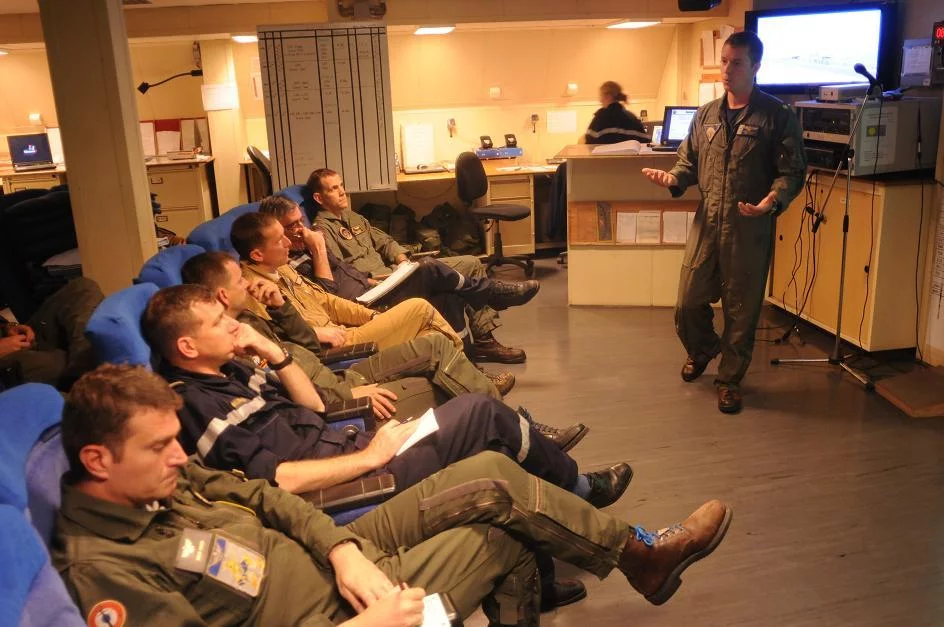 Le Cmdr. Michael Sweeney briefe les officiers de la marine nationale sur les exercices communs