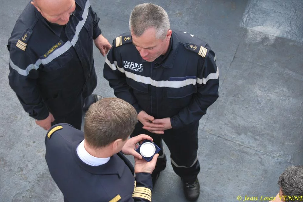 Le commandant actuel remet à un de ses prédécesseurs une médaille et une casquette