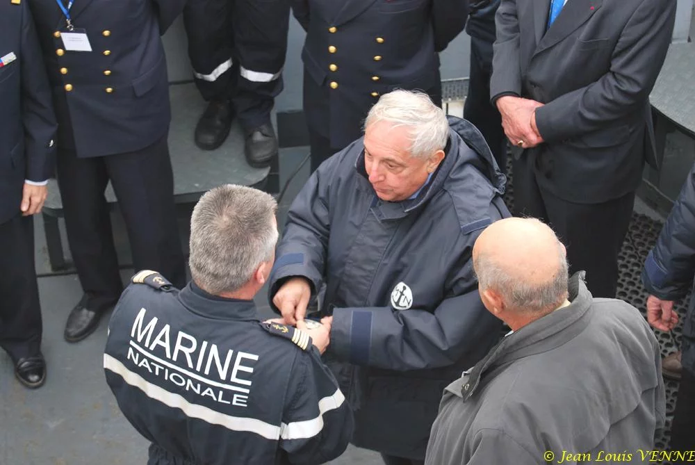 Le commandant actuel remet à un de ses prédécesseurs une médaille et une casquette
