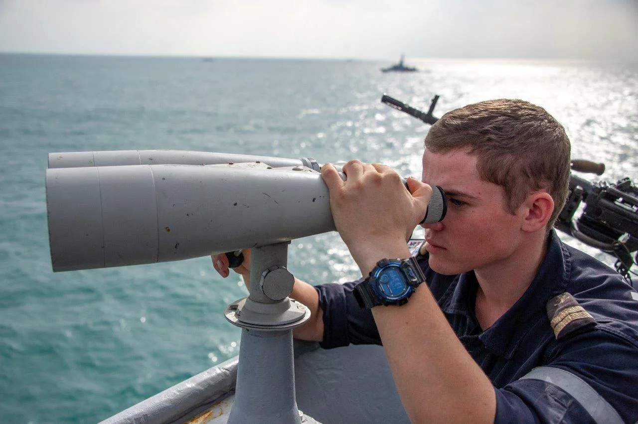 Un veilleur surveille la situation surface avec des jumelles