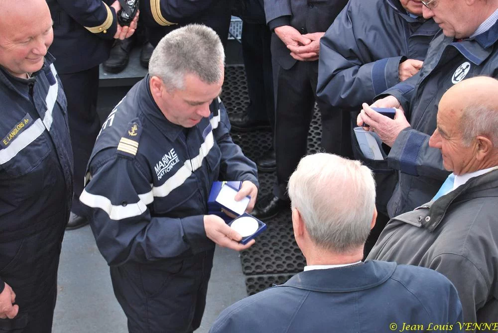 Le commandant actuel remet à un de ses prédécesseurs une médaille et une casquette