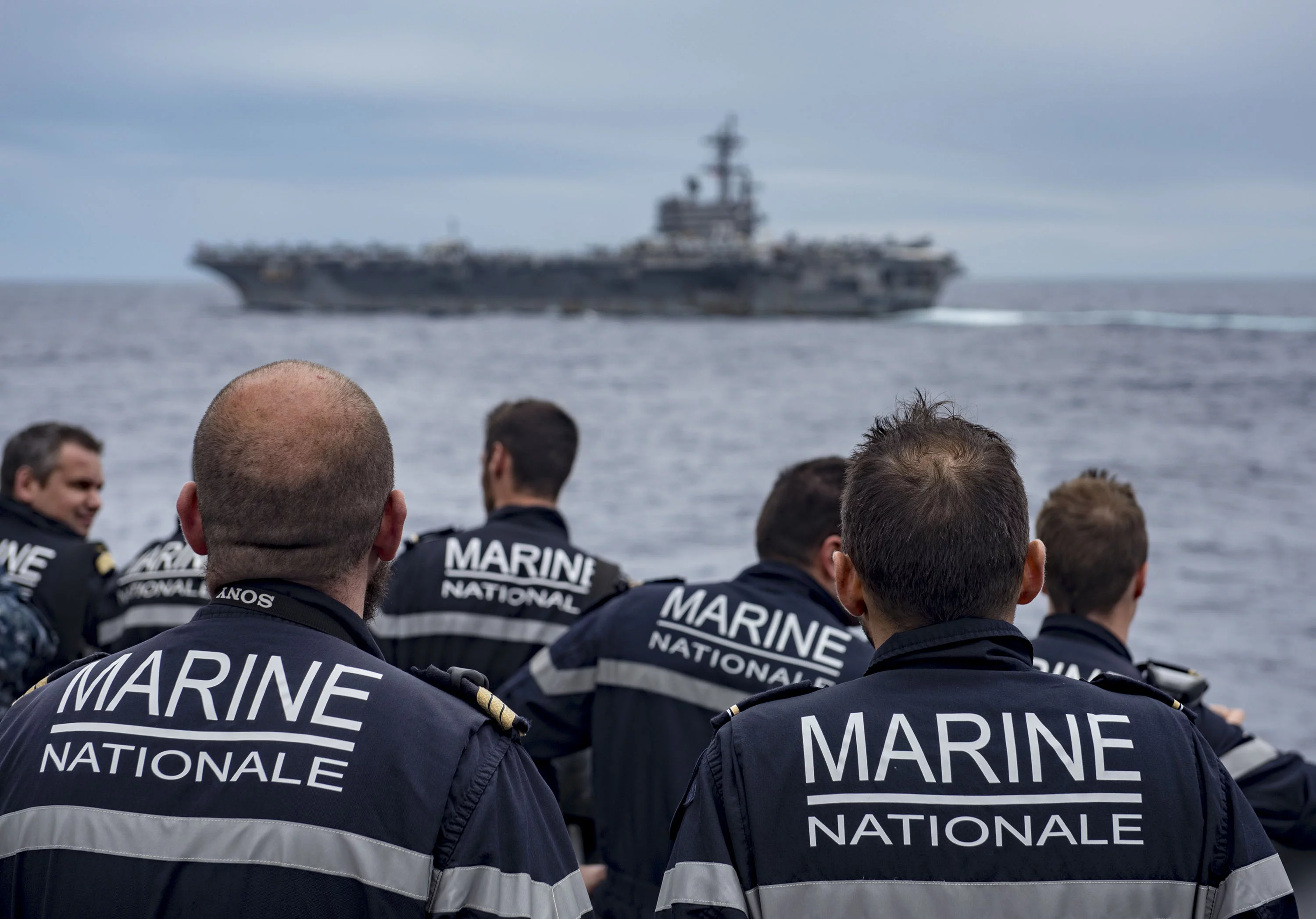 Des marins de la frégate Forbin regardent passer le porte-avions USS George H.W. Bush