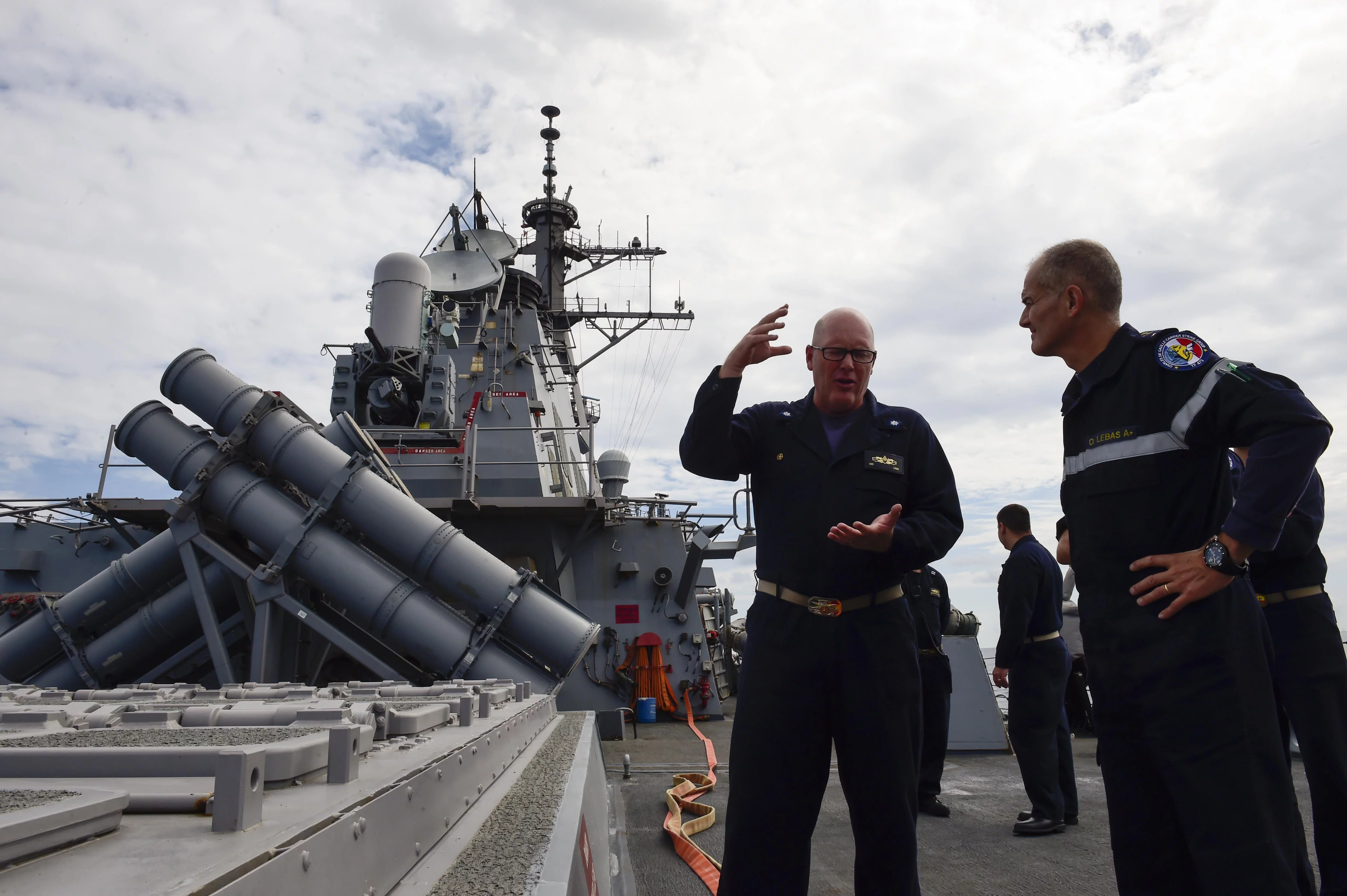 Le Cmdr. Russell Caldwell, commandant de l’USS Ross, fait visiter son destroyer au contre-amiral Lebas