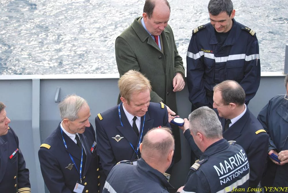 Le commandant actuel remet à un de ses prédécesseurs une médaille et une casquette