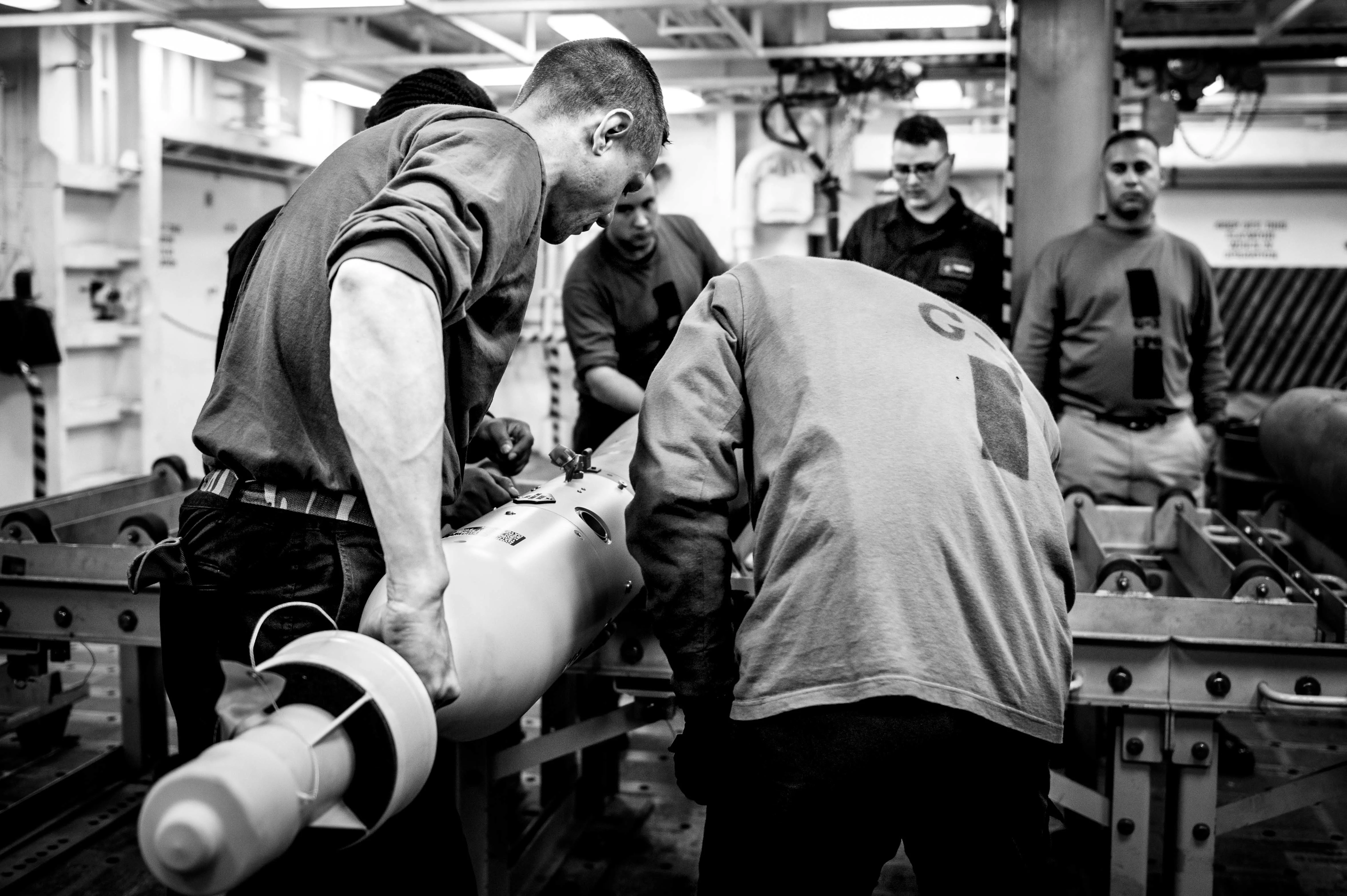 Marins français et américains s'entraînent à armer une munition d'exercice