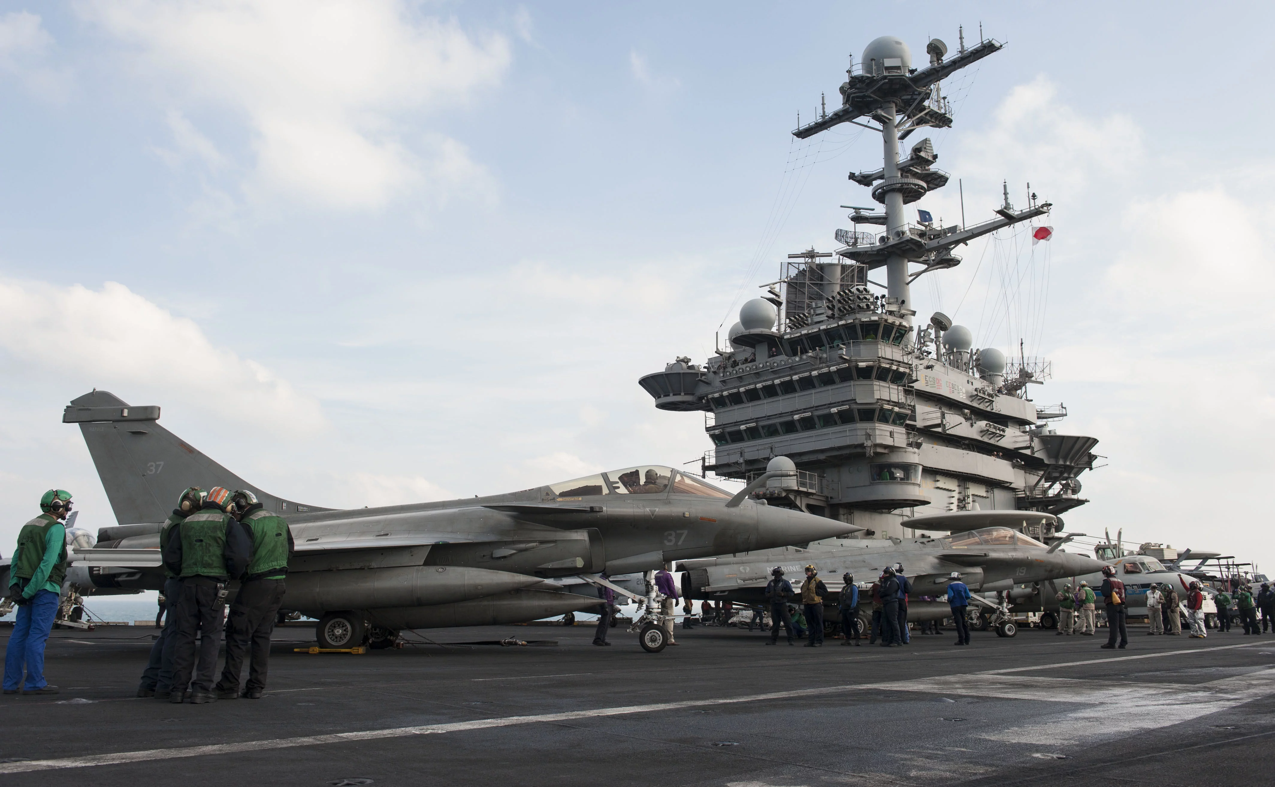 Deux Rafale du Charles de Gaulle sont ravitaillés sur le pont d'envol du porte-avions USS Harry S. Truman