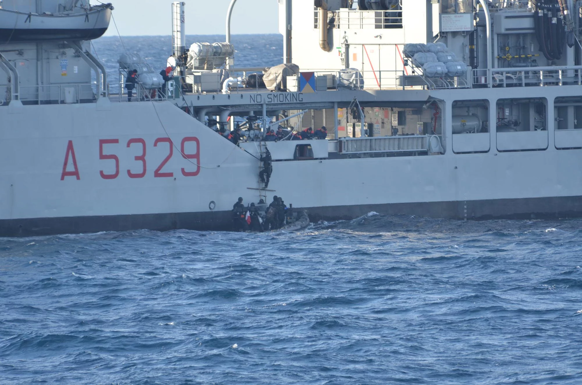 L'équipe de visite du Jean de Vienne monte à bord du Vesuvio grâce à l'échelle de pilote