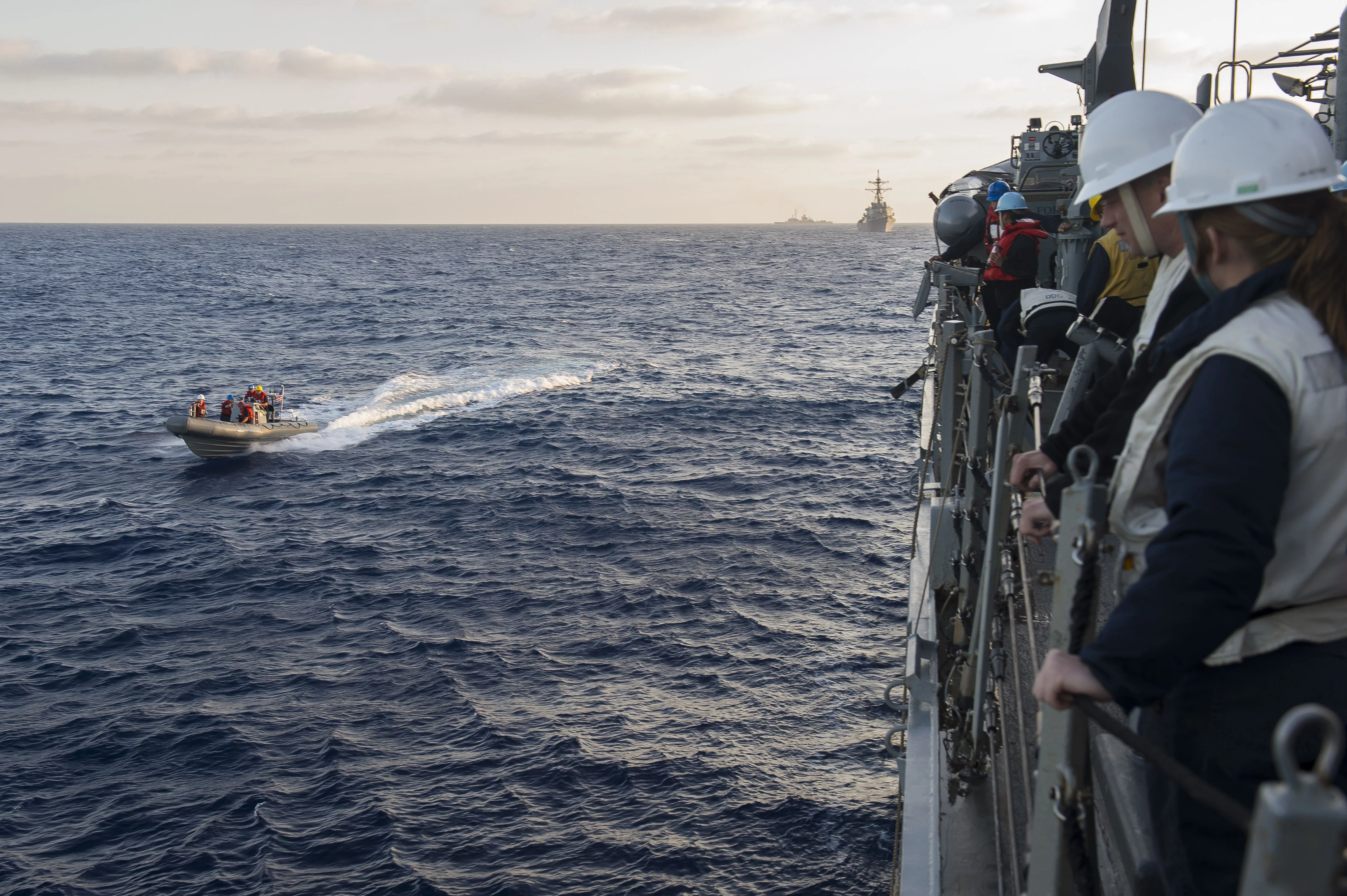 Une embarcation du destroyer USS Ross participe à un exercice de type passex avec le destroyer USS Laboon et la frégate Cassard