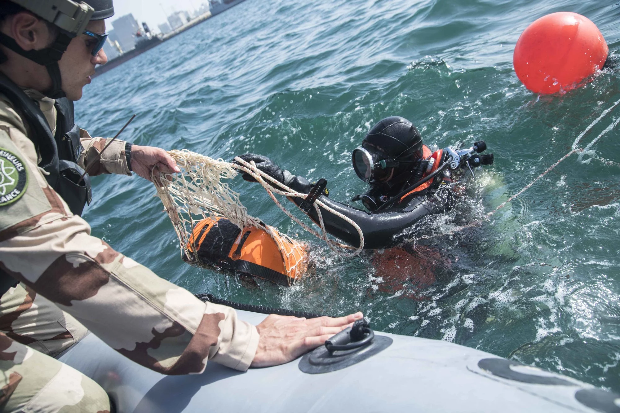 Les plongeurs démineurs remontent la mine fixée sur la coque de la frégate