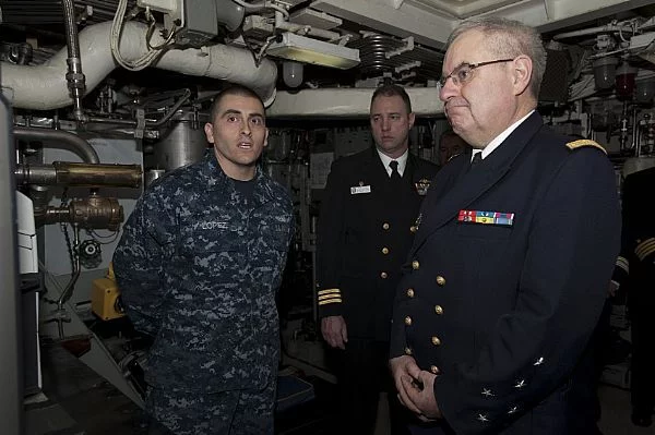 Le mécanicien de 1ère classe Jerry Lopez fait visiter une partie du SNLE USS Rhode Island à l'amiral Rogel