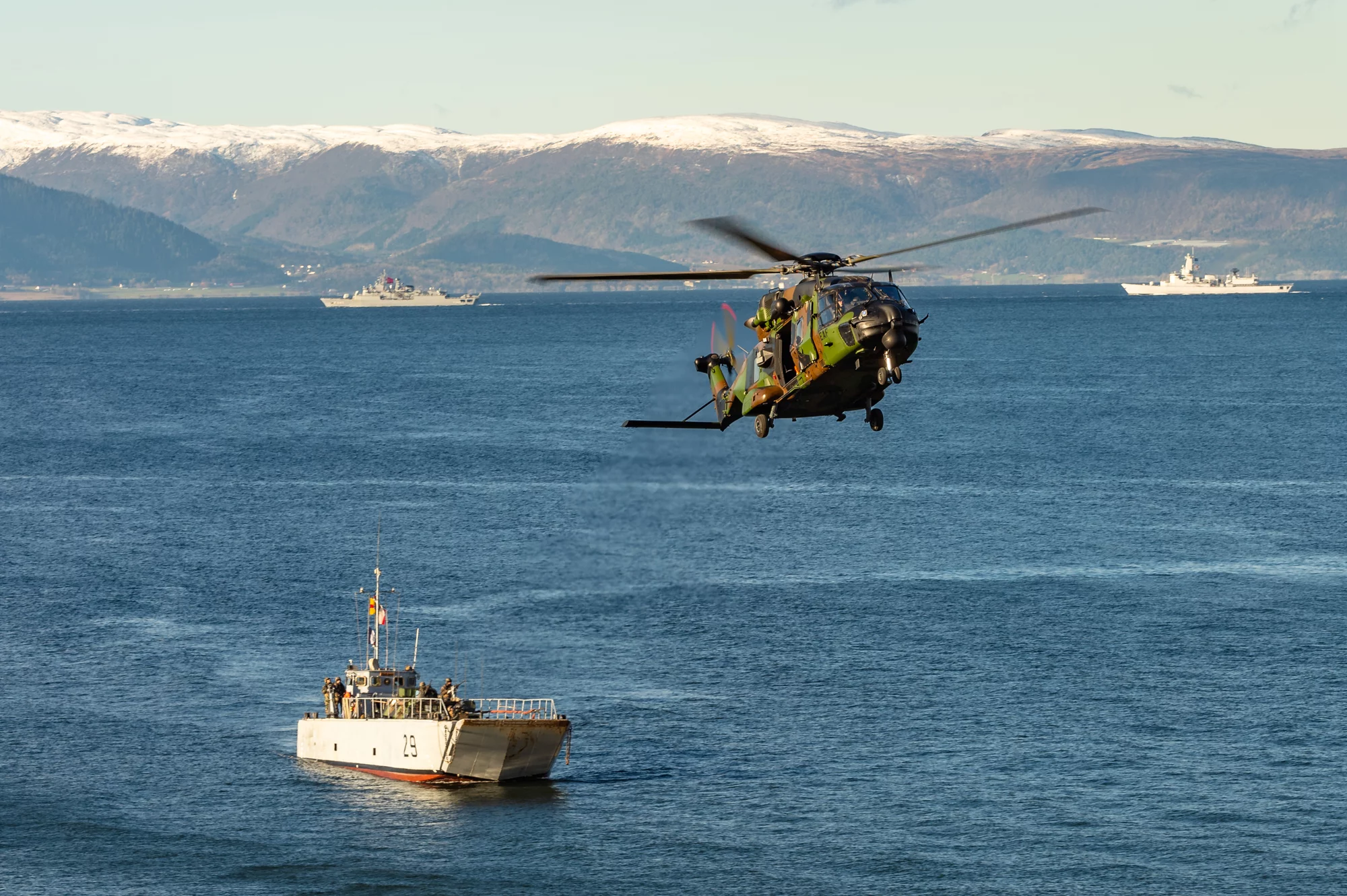 Un hélicoptère survole un chaland de transport de matériel