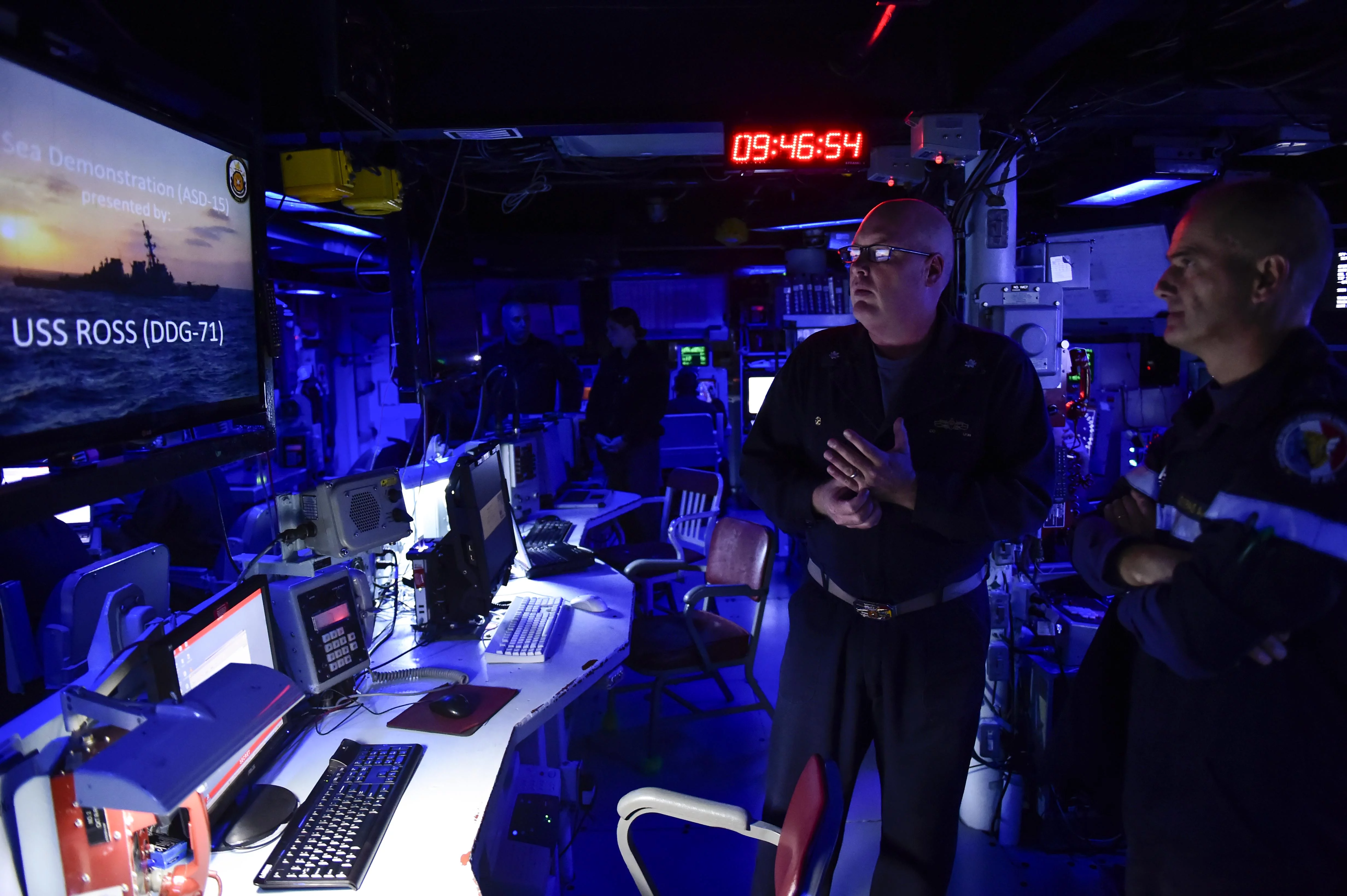 Le Cmdr. Russell Caldwell, commandant de l’USS Ross, fait visiter son destroyer au contre-amiral Lebas