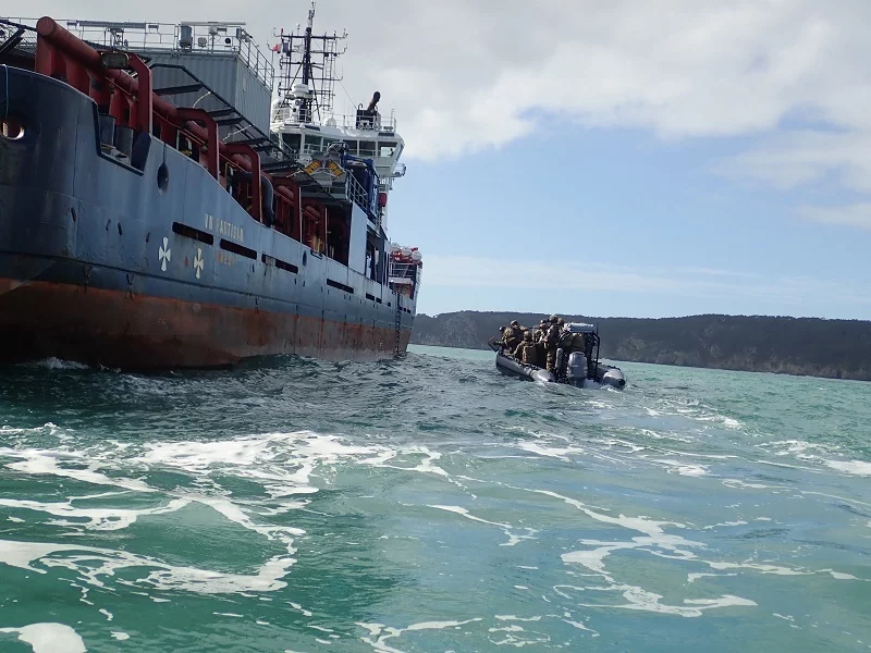 L'équipe de visite du Commandant Blaison s'approche d'un bâtiment