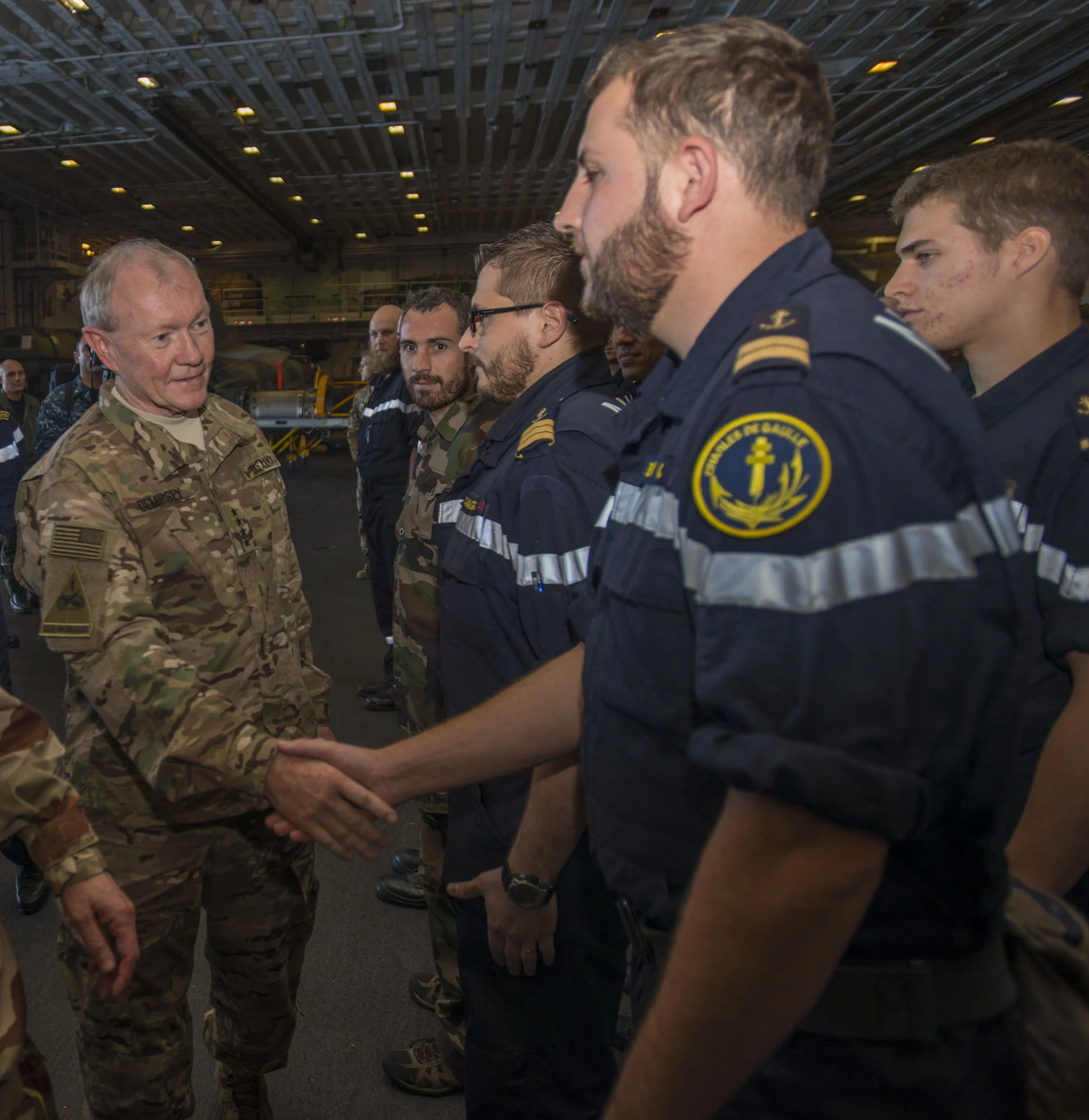 Le général Martin Dempsey, chef d’état-major des armées américaines, salue des marins français dans le hangar du Charles de Gaulle