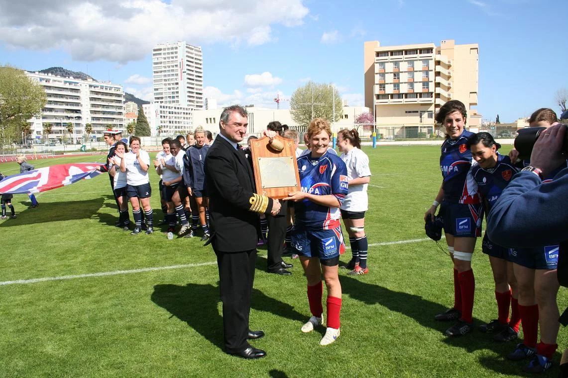 Le responsable de l'équipe britannique remet la plaque au capitaine de l'équipe victorieuse