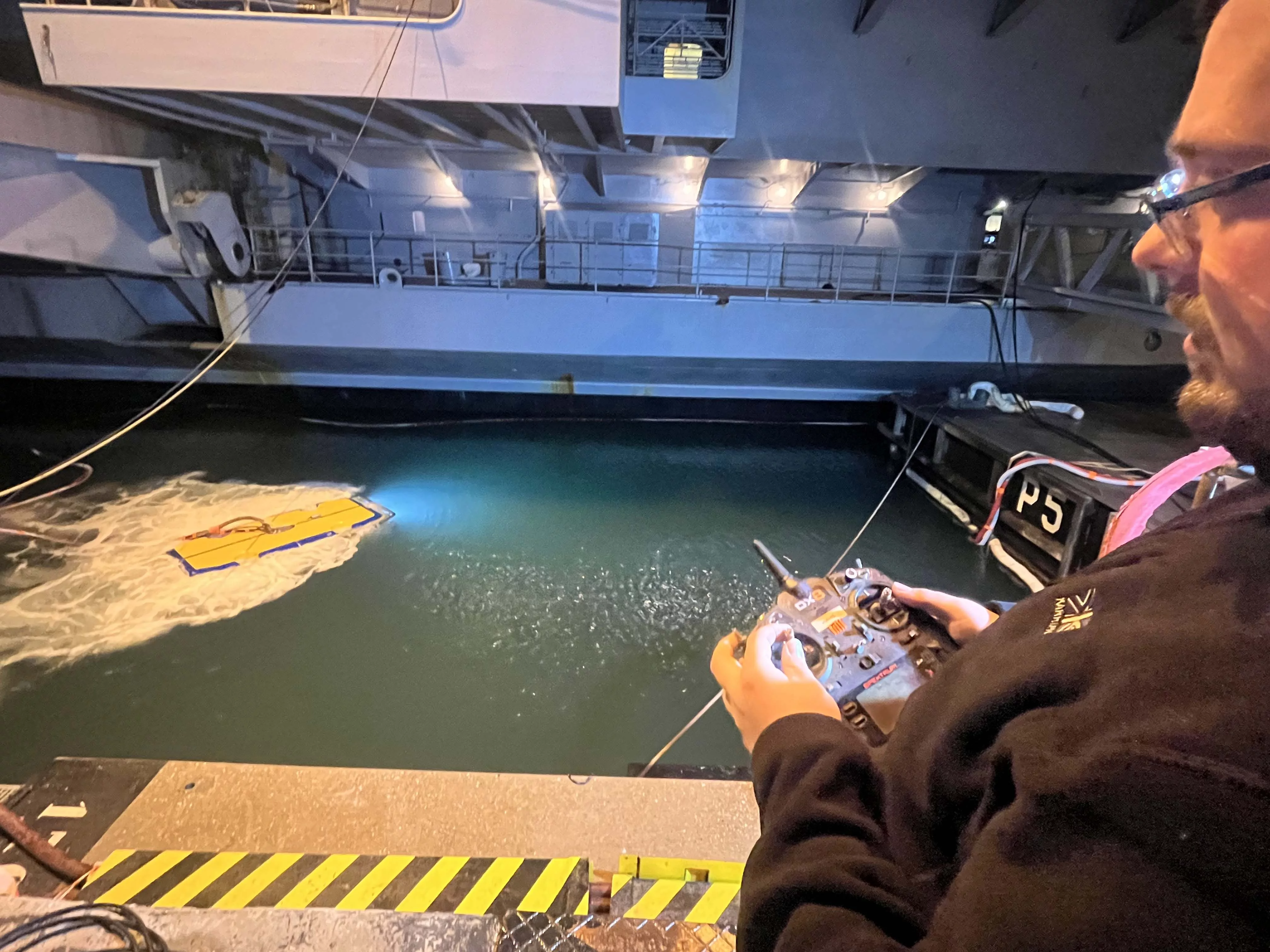 Le drone inspectant la coque du porte-avions